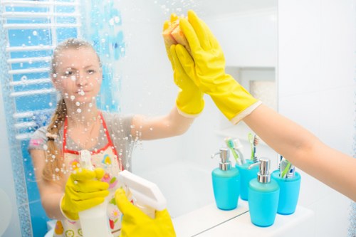 Professional domestic cleaner sanitizing a kitchen countertop